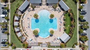 An aerial view of a hotel with a central swimming pool, multiple lounge areas, and parking spaces. - 30A Top Rated! Free Golf Cart+Bikes+2 Pools+Bunks (Inlet Beach)