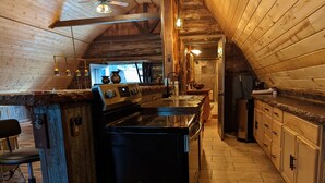 Eine Küche mit Kochinsel, Holzschränken und Deckenventilator.
