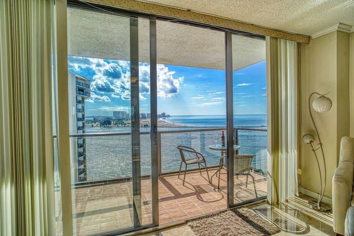 Un balcón con vista al mar y al paisaje urbano.
