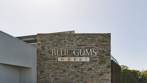 A hotel sign with the name "BLUE GUMS HOTEL" on a stone facade. - Blue Gums Hotel (Fairview Park)