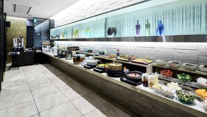 A buffet area with a variety of food items and a coffee station.