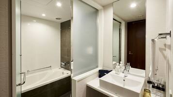 A modern bathroom with a glass shower enclosure, a double sink vanity, and a large mirror.