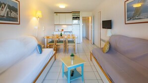 A compact living space with two sofas, a dining table, a kitchen area, and a TV. - Beautiful apartment for 6 guests with pool, WIFI, TV, terrace and pets allowed (Saint-raphaël)