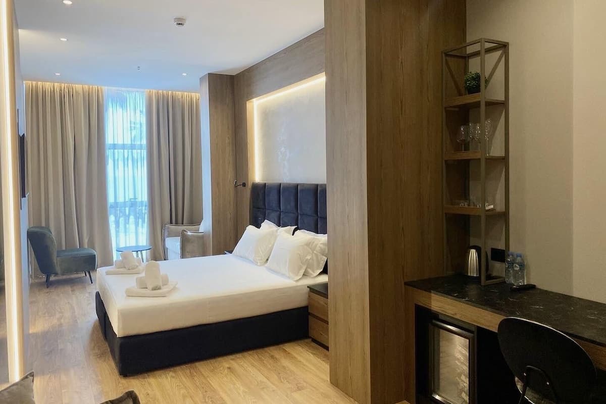 Une chambre d’hôtel moderne, dotée d’un grand lit, d’un bureau et d’une chaise.