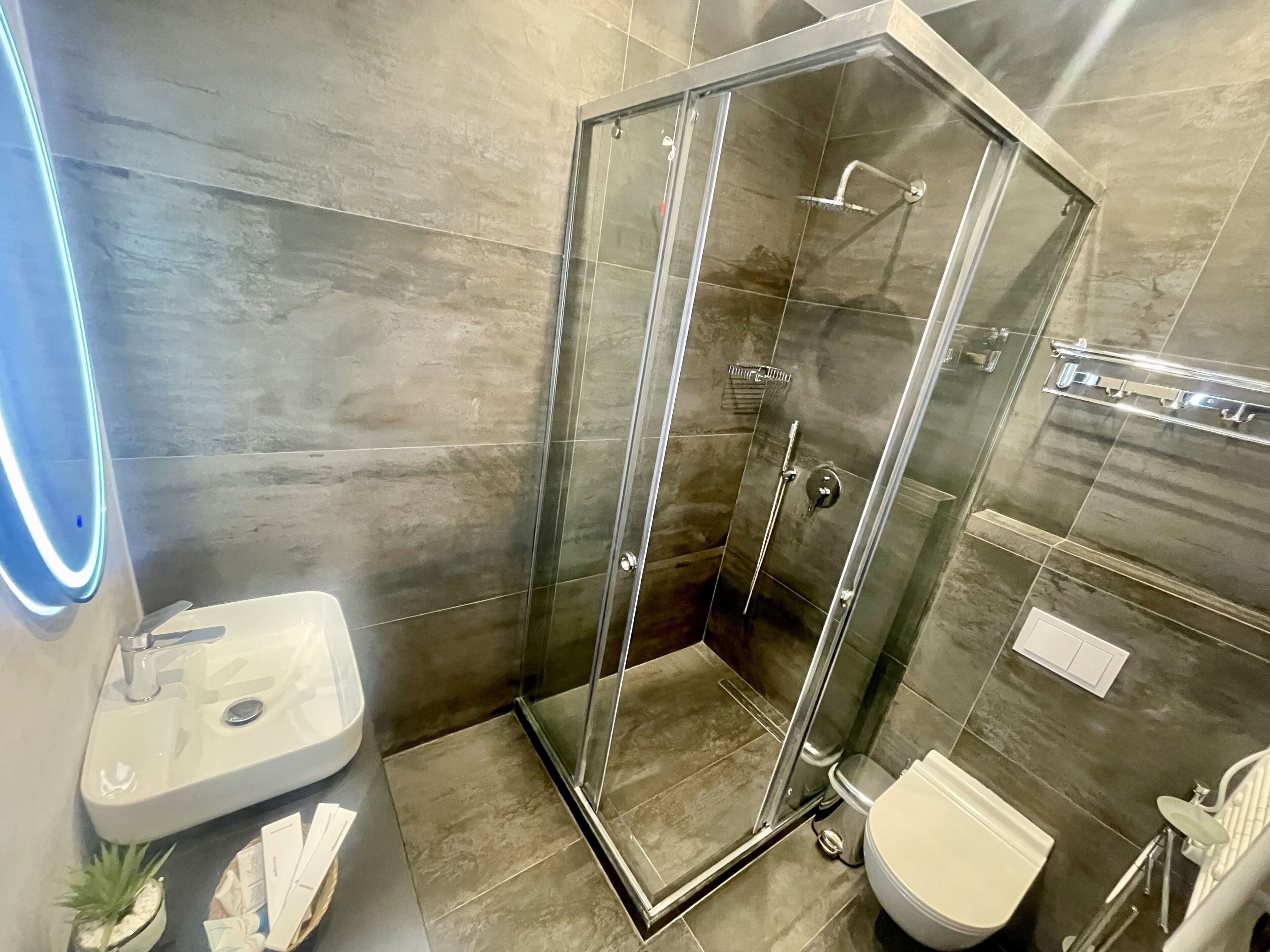 Une salle de bain moderne avec une douche à parois de verre, un lavabo et des toilettes.