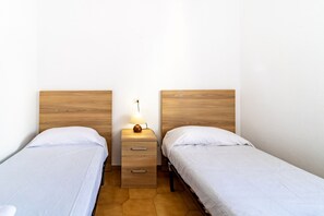 3 dormitorios, tabla de planchar con plancha, ropa de cama