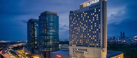 Two high-rise buildings with illuminated signage, one labeled "St. Giles Hotels" and the other with various commercial signs.