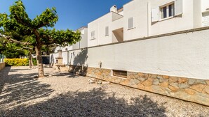 A building with a stone foundation and white walls, featuring a chimney and a window with shutters. - Sant Carles 24 - apartment with terrace (Llança)