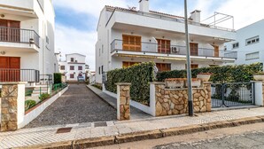 A residential street with white buildings, stone walls, and a paved road. - Sant Carles 25 - apartment with terrace (Llança)