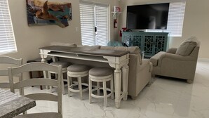 A living room with a dining area, a television, and a fire extinguisher. - Key Largo New Construction 2-story! Exclusive Rights for 28 Days! (Key Largo)