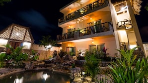 A multi-story hotel with balconies, a pool, and tropical landscaping. - Jaakbal Tulum (Tulum)