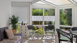 A sunlit room with a sofa, two chairs, a table, and a potted plant. - Apartment 'Fuldatalblick' with Garden & Wi-Fi (Fulda)