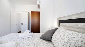 A bedroom with a bed, a wardrobe, a door, and an air conditioning unit. - Holiday Home La Alberca with Pool, Garden and Wi-Fi (Chiclana de la Frontera)