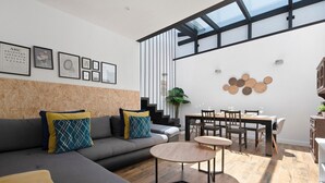 Un salon moderne avec un canapé, une table basse et un coin repas.