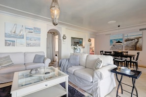A living room with a sofa, coffee table, and artwork on the walls.