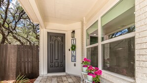 A house entrance with a dark door, a white picket fence, and a brick wall. - Elite Retreat w/ pool table & shuffleboard @ La Cantera, Six Flags, RIM, UTSA (San Antonio)