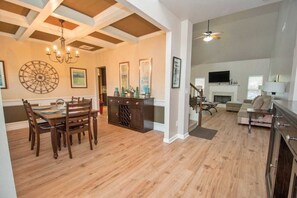 A spacious living area with a fireplace, a dining area with a wooden table and chairs, and a kitchen with dark cabinetry. - 5-Star Luxury Home Sleeps 22+ Airport proximity (Union City)