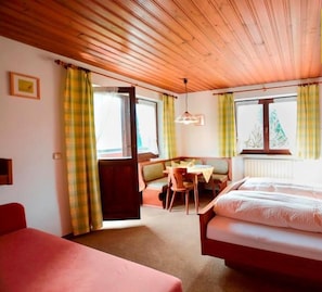 Een gezellige kamer met een bed, een klein tafeltje en een bankje.