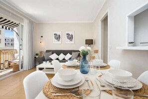 Relax in this inviting living area with a sofa, dining table, and potted plant.
