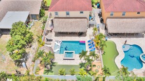 A resort with two buildings, a swimming pool, and a small children's pool. - 5 Mins to beach; 5BD, 4.5BA, Heated pool, Jacuzzi, Mini Golf, Tiki Huts.  (Boynton Beach)