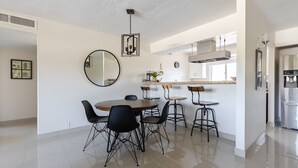 Une cuisine moderne dotée d’un îlot central, de tabourets de bar et d’une table à manger avec des chaises.