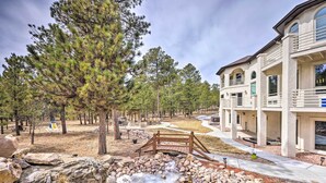 A building with a stone facade, a wooden bridge, and a natural landscape with trees and a rocky stream. - Estate w/ Indoor Pool & Decks ~ 25 Mi to Dtwn (Colorado Springs)