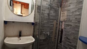Een douche, een bidet, handdoeken, toiletpapier