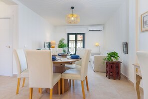 Een eetruimte met een tafel voor vier personen, omringd door stoelen met houten poten.