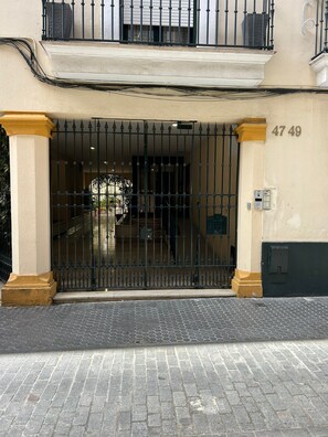 A building entrance with a metal gate, a mailbox, and a number '47 49' on the wall.