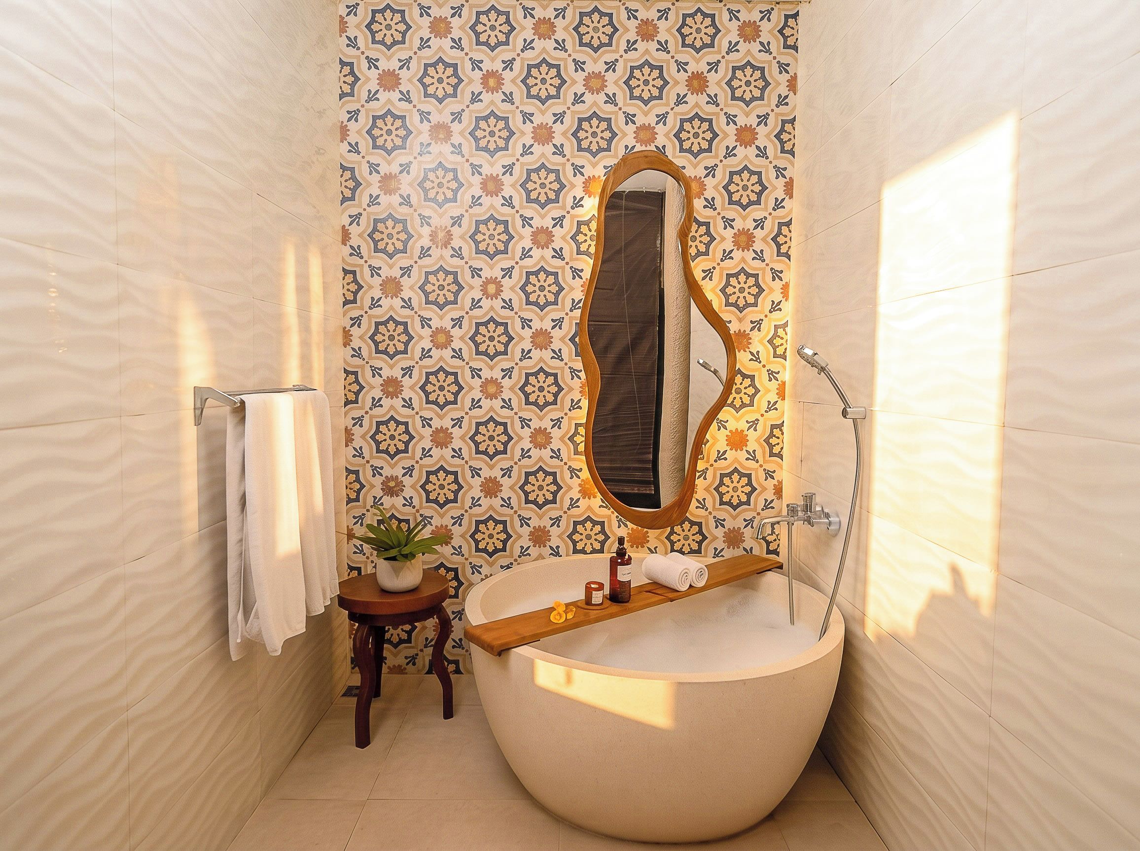 Une salle de bain avec une baignoire sur pieds, une étagère en bois où sont rangés les articles de toilette, une plante en pot et un porte-serviettes.