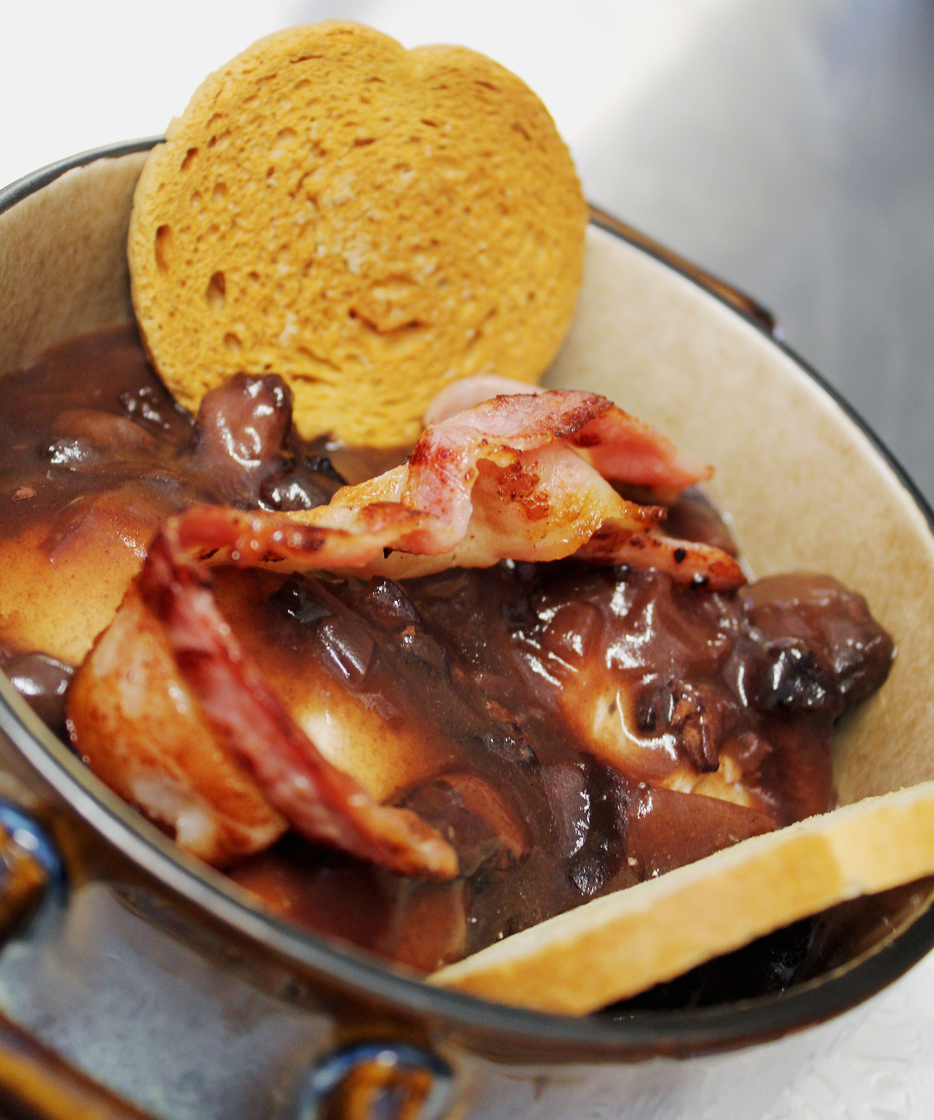 Un plato de comida con un trozo de carne y una galleta.
