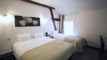 A hotel room with two beds, a painting on the wall, and a wooden chair.