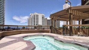 A rooftop pool with a clear view of the ocean, surrounded by high-rise buildings. - Discovery Bay-Resolution Ocean View Condo (Honolulu)
