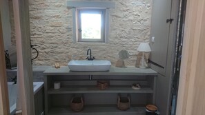 Een bad/douchecombinatie, een haardroger, handdoeken, zeep