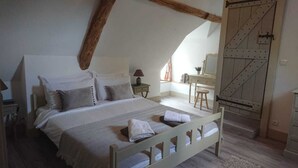 Un dormitorio con cama, escritorio y armario.