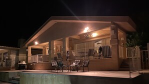 Ein überdachter Außenbereich mit Pool, Sitzgelegenheiten und Grill.