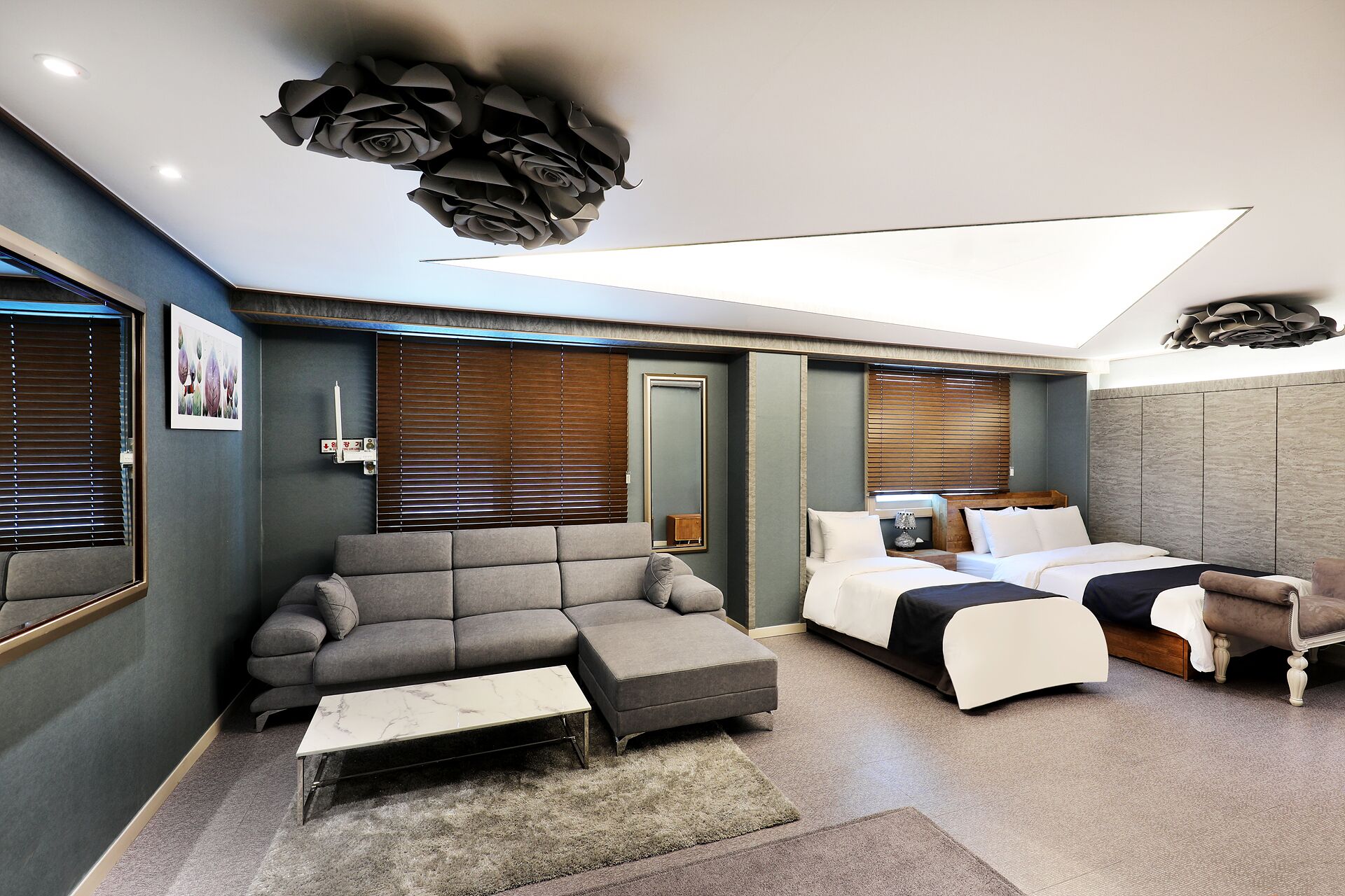 A modern bedroom with a sofa, a bed, and a desk.