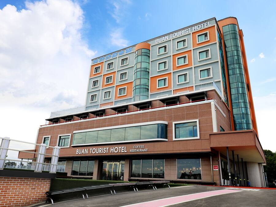 A multi-story hotel with a modern design, featuring a coffee restaurant on the ground floor.