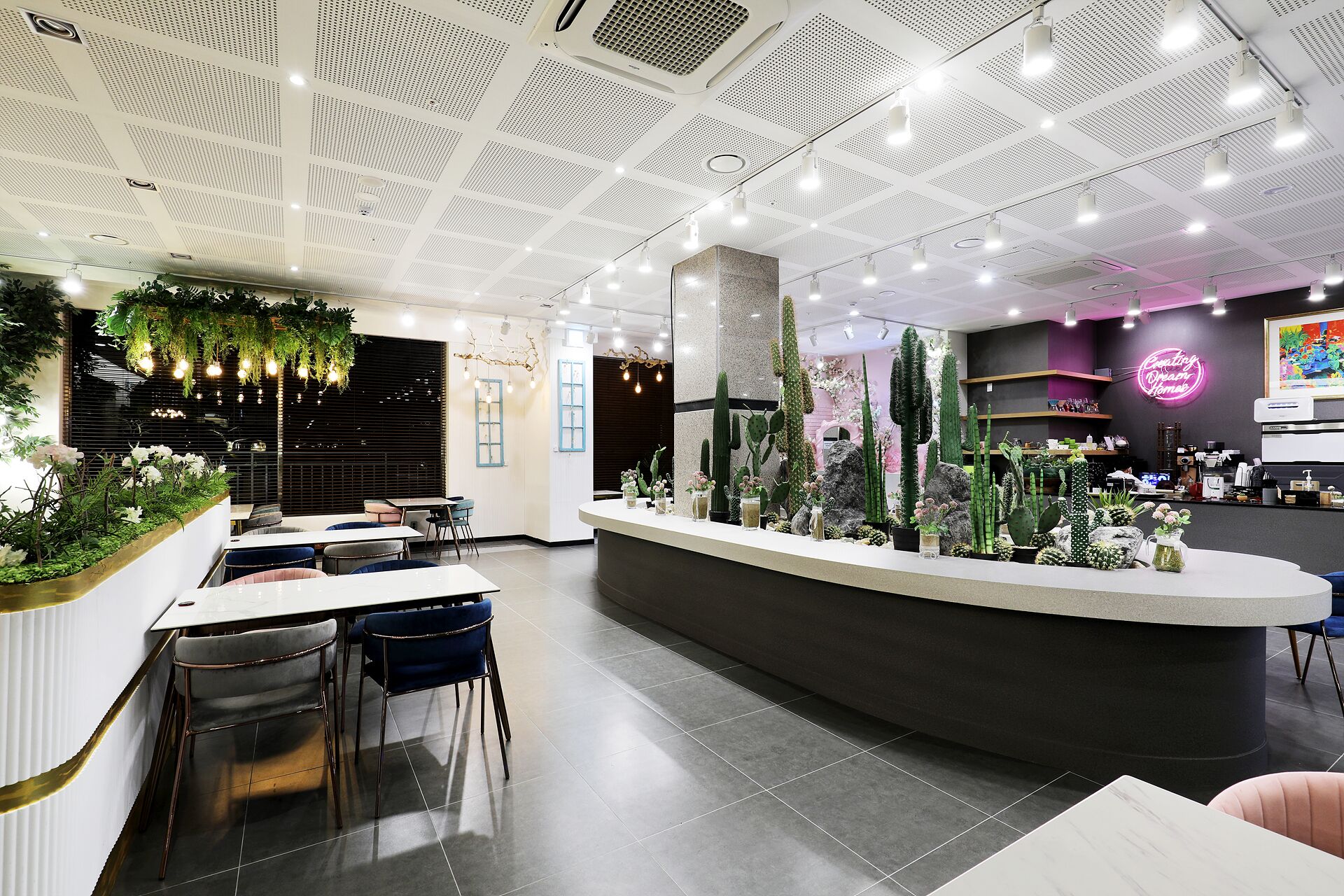 Un interior moderno con mostrador de recepción, zona de estar y plantas decorativas.