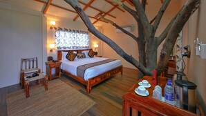 Ein Schlafzimmer mit einem großen Bett, Holzmöbeln, einem Couchtisch und einem Ast in der Mitte.