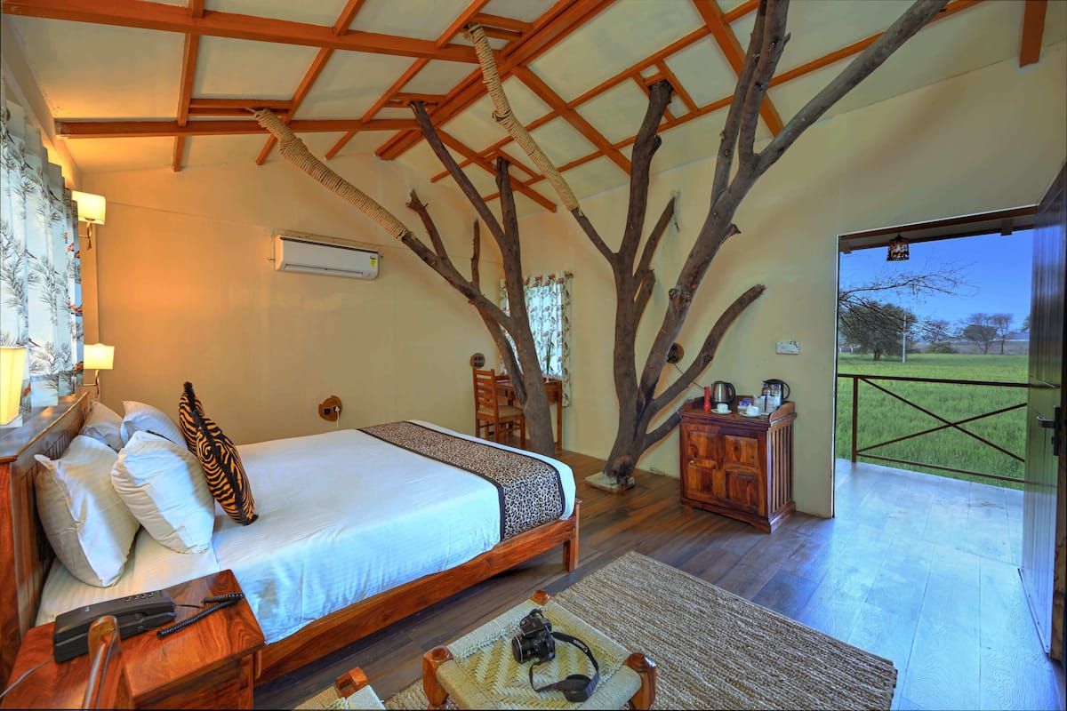 Une chambre à coucher avec un lit, une tête de lit en bois et une grande fenêtre.