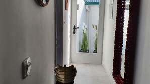 A hallway with a clock, a mirror, and a door leading to a room with plants. - IN Fresh - Holiday House IN Šibenik Near Center AND Beach With Parking (Šibenik)