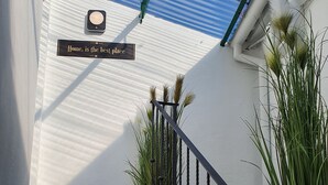 A staircase with a metal railing, a potted plant, and a sign that reads "Home, is the best place". - IN Fresh - Holiday House IN Šibenik Near Center AND Beach With Parking (Šibenik)