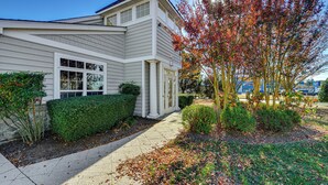 A two-story house with a front yard, a driveway, and a tree with autumn leaves. - 2 Mi to Beach: Townhome w/ Breezy Balcony! (Rehoboth Beach)