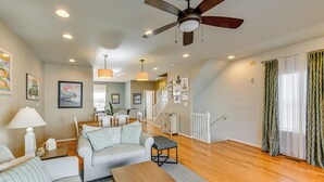 A spacious living room with a ceiling fan, a dining area, and a staircase leading to an upper level. - 2 Mi to Beach: Townhome w/ Breezy Balcony! (Rehoboth Beach)