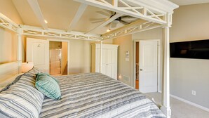 A bedroom with a four-poster bed, a walk-in closet, and a television on the wall. - 2 Mi to Beach: Townhome w/ Breezy Balcony! (Rehoboth Beach)