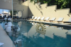 Una piscina al aire libre de temporada, sillones reclinables de piscina