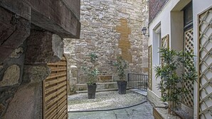 A narrow courtyard with stone walls, two potted plants, and a wooden gate. - Super calm cosy & cute 2 bdr at the heart of Old Honfleur- Duplex Le Pélican ★★★★ (Honfleur)