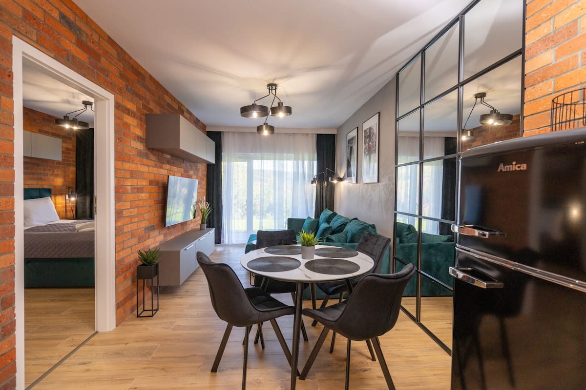 Un espace de vie moderne comprenant un coin repas, une cuisine et une chambre.