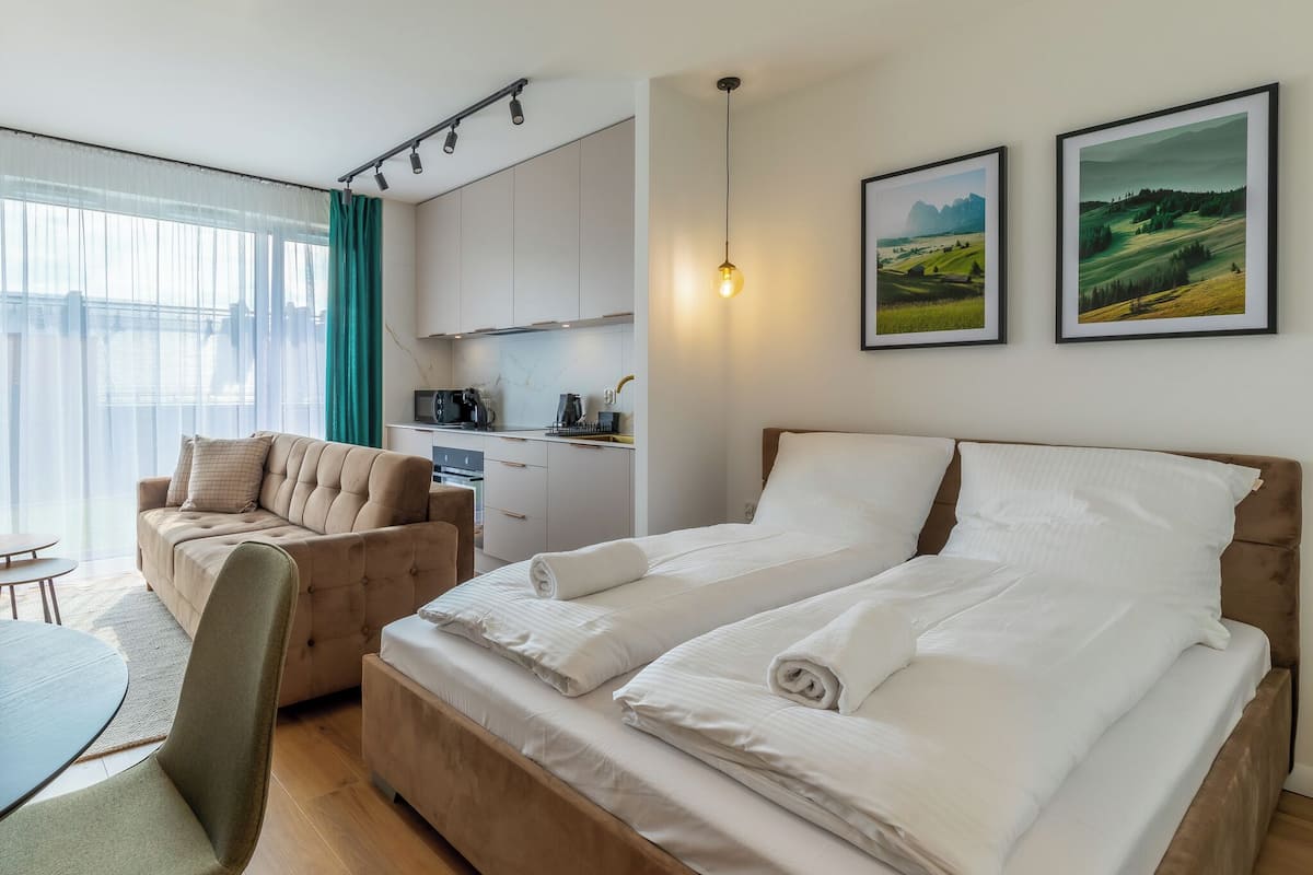 Une chambre d’hôtel comprenant un lit, un canapé, une table à manger et un coin cuisine.